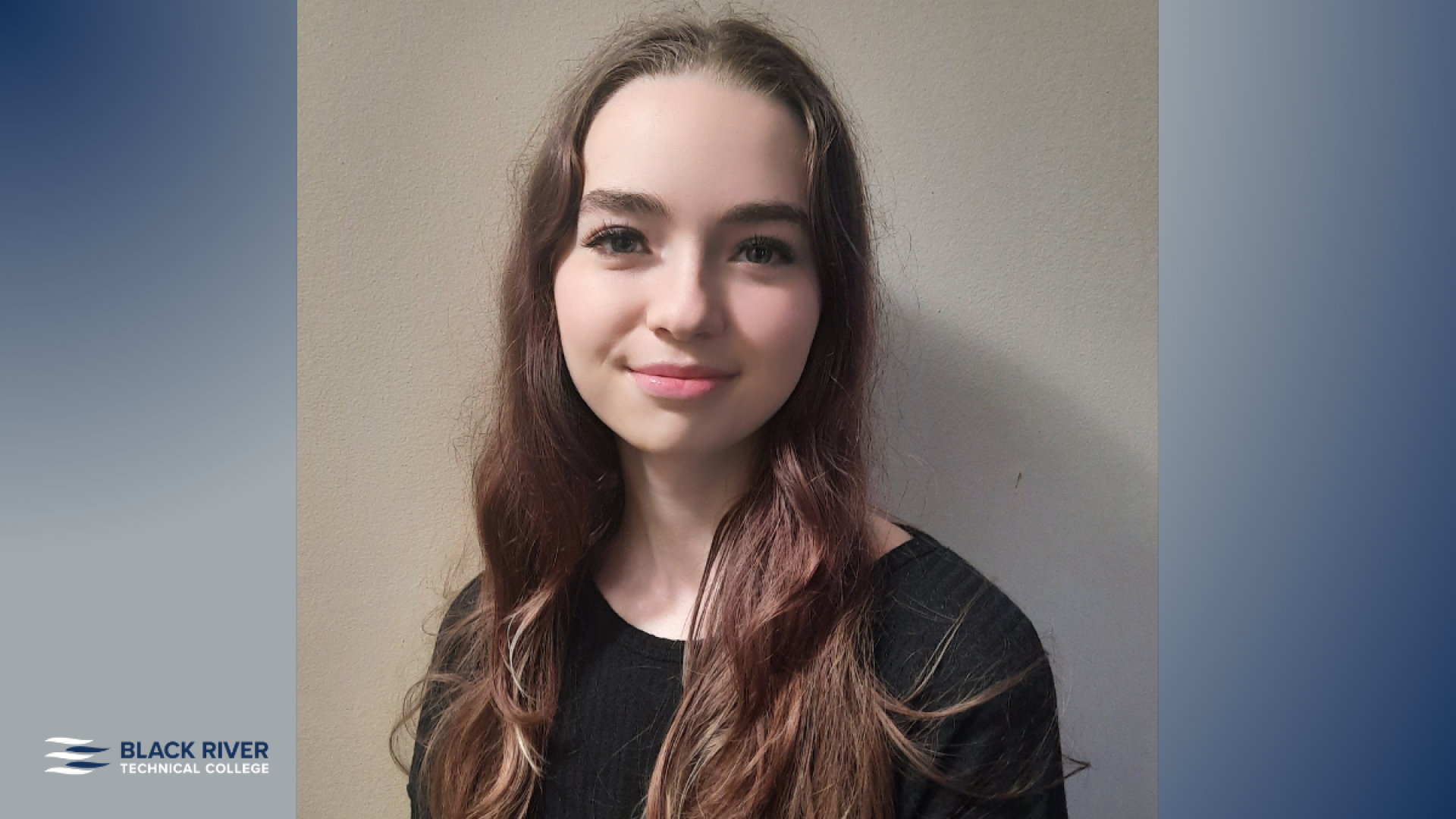 A young woman with long brown hair, wearing a black top, smiles gently against a plain tan wall, with Black River Technical College branding.